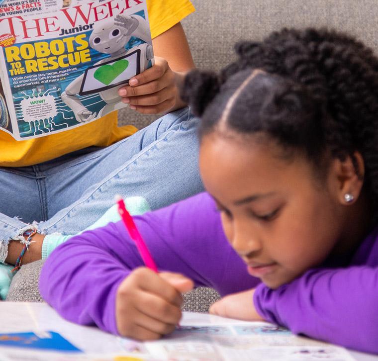 A girl writing something in a magazine with a pencil